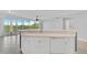 Open kitchen with island, white cabinets and a view of the living room at 393 N Point Rd # 503, Osprey, FL 34229