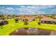 Community view showcasing homes with tile roofs near a pond at 12656 Felice Dr, Venice, FL 34293