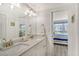 Double vanity bathroom with speckle countertop and a view into the bedroom at 4360 Chatham Dr # F204, Longboat Key, FL 34228