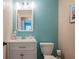 Small bathroom with white vanity, toilet, and teal walls at 213 75Th St, Holmes Beach, FL 34217