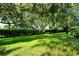 Beautiful backyard scene with manicured lawn and lush trees providing privacy at 4072 Fairway Pl, North Port, FL 34287