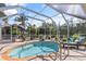 Enclosed kidney-shaped pool with lounge chairs at 4108 101St W St, Bradenton, FL 34210
