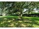 Large backyard with shade trees and green grass at 4072 Fairway Pl, North Port, FL 34287
