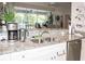 Kitchen features granite countertops, double sink, and views to the pool at 6772 Greenview Ln, Englewood, FL 34224