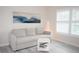 Living room with a sofa, side table, floor lamp, and window with shutters at 6772 Greenview Ln, Englewood, FL 34224