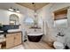 Elegant bathroom featuring a freestanding soaking tub, modern vanity, and textured wall at 12307 S Access Rd, Port Charlotte, FL 33981