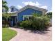 Charming blue house with brick paver driveway and lush landscaping at 213 75Th St, Holmes Beach, FL 34217