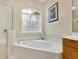 Bathroom featuring a corner bathtub and large vanity with wood cabinets at 6747 Coyote Ridge Ct, Bradenton, FL 34201