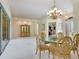 Elegant dining room featuring a glass-top table and chandelier, adjacent to a home office at 6747 Coyote Ridge Ct, Bradenton, FL 34201