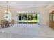 Bright dining room with glass-top table, chandelier, and view of backyard at 6747 Coyote Ridge Ct, Bradenton, FL 34201