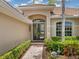 Front entrance with double doors and lush landscaping at 6747 Coyote Ridge Ct, Bradenton, FL 34201