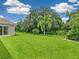 Large backyard with a grassy area and tropical vegetation at 6747 Coyote Ridge Ct, Bradenton, FL 34201