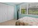 Bedroom with floral bedding, window with blinds, and white closet doors at 5026 Water Oak Dr # 119, Bradenton, FL 34207