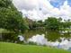 Serene pond with lush greenery and reflections of clouds at 5026 Water Oak Dr # 119, Bradenton, FL 34207