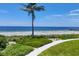 Landscaped path leading to the beach with palm trees at 2251 Gulf Of Mexico Dr # 301, Longboat Key, FL 34228