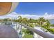 Balcony with glass railing and tropical views at 2251 Gulf Of Mexico Dr # 301, Longboat Key, FL 34228