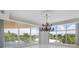 Bright dining room with large windows, chandelier, and hardwood floors at 2251 Gulf Of Mexico Dr # 301, Longboat Key, FL 34228