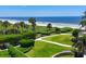 Expansive beachfront lawn with lush landscaping and ocean views at 2251 Gulf Of Mexico Dr # 301, Longboat Key, FL 34228