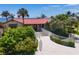 Oceanfront home with red tile roof, stone exterior, and lush landscaping at 2251 Gulf Of Mexico Dr # 301, Longboat Key, FL 34228