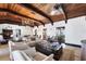 Spacious living room with high ceilings, exposed beams, and a stone fireplace at 2251 Gulf Of Mexico Dr # 301, Longboat Key, FL 34228