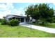 Ranch-style home with carport and mature landscaping at 2434 Fourwind St, Port Charlotte, FL 33948