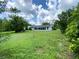 Large backyard with a spacious lawn and mature trees at 2434 Fourwind St, Port Charlotte, FL 33948
