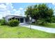 Ranch-style home with carport and mature landscaping at 2434 Fourwind St, Port Charlotte, FL 33948