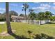 Large backyard with a white fence, lush lawn and tropical plants at 1914 24Th W Ave, Palmetto, FL 34221