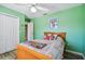 Cozy bedroom with light green walls, double doors, and a wooden bed frame at 1914 24Th W Ave, Palmetto, FL 34221