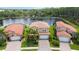 Aerial view of three houses with red tile roofs, near a lake at 1048 Bradberry Dr, Nokomis, FL 34275