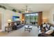Spacious living room boasts leather furniture, a large TV, and sliding glass doors leading to a patio at 9861 50Th Street E Cir, Parrish, FL 34219