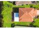 Aerial view of home with tile roof, screened in porch, lawn, and lake at 11492 Dancing River Dr, Venice, FL 34292
