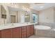 A luxurious bathroom boasts a garden tub, double vanity, and a separate shower at 11492 Dancing River Dr, Venice, FL 34292