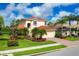 Beautiful two-story home featuring a well-manicured lawn, tropical landscaping, and terracotta tile roof at 11492 Dancing River Dr, Venice, FL 34292