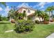 Beautifully landscaped home with mature trees, flowers, and a well-maintained lawn at 11492 Dancing River Dr, Venice, FL 34292