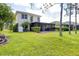 View of the backyard, with lush green lawn and screened in porch on a two-story home at 11492 Dancing River Dr, Venice, FL 34292