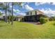 Two-story home featuring a backyard with screened in porch overlooking a lawn and mature landscaping at 11492 Dancing River Dr, Venice, FL 34292