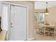 Bright entry with white door, open dining area with seating for six, and natural light at 11492 Dancing River Dr, Venice, FL 34292