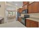 Bright kitchen with wood cabinetry, stainless steel appliances, and view to the breakfast nook at 11492 Dancing River Dr, Venice, FL 34292