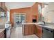 Open concept kitchen featuring wood cabinets, stainless appliances, and views of the living and dining areas at 11492 Dancing River Dr, Venice, FL 34292
