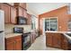Efficient kitchen features wood cabinets, stainless appliances, breakfast bar, and slider to the lanai at 11492 Dancing River Dr, Venice, FL 34292