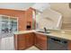 Open concept kitchen offers a breakfast bar, sink with dishwasher, and views of the living area at 11492 Dancing River Dr, Venice, FL 34292