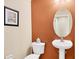 Powder room featuring a toilet and pedestal sink against a color-blocked wall at 11492 Dancing River Dr, Venice, FL 34292