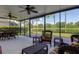 Inviting screened porch with comfortable seating, perfect for enjoying serene lake views and outdoor living at 11492 Dancing River Dr, Venice, FL 34292
