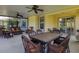 Relaxing outdoor screened porch featuring wicker furniture and ceiling fans, great for gatherings at 11492 Dancing River Dr, Venice, FL 34292