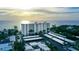 High-rise building overlooks the beach with carports, and mature tropical trees at 20 Whispering Sands Dr # 501, Sarasota, FL 34242