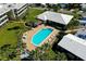 Aerial view of a community pool with ample seating, lush landscaping and mature palms at 20 Whispering Sands Dr # 501, Sarasota, FL 34242