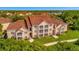 Aerial view of a two-story building with Spanish tile roofing in a lush setting at 4126 Central Sarasota Pkwy # 2026, Sarasota, FL 34238