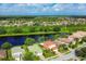 Aerial view of a community with houses and a lake at 11492 Dancing River Dr, Venice, FL 34292