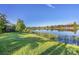 Landscaped backyard with lake view, lush greenery, and a relaxing atmosphere at 5234 Castello Ln, Lakewood Ranch, FL 34211